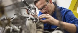 Un méchanicien automobile est en train de travailler sur un moteur de voiture dans son garage